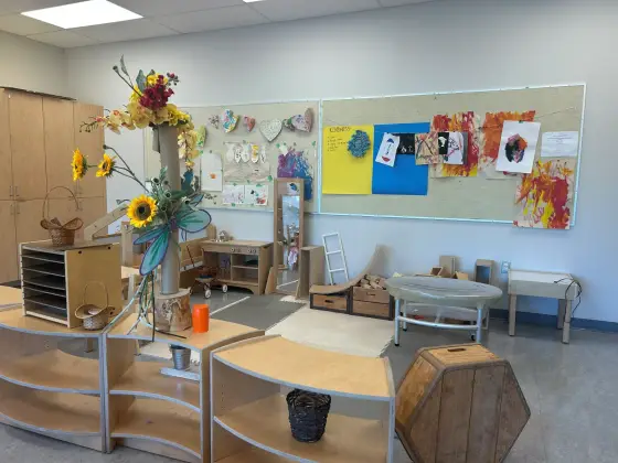 Display boards of children's artwork in the Butterfly Room, beside open shelving and a seasonal flower display